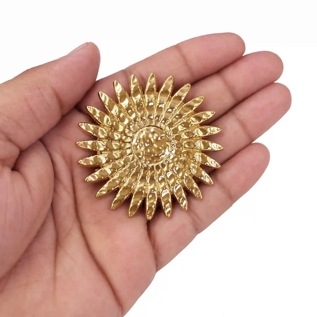 ANI Accessories sun shaped brooch held in hand to show its size 