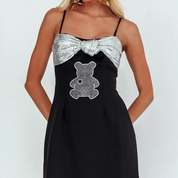ANI Accessories white teddy bear patch stitched on the front of a woman's black dress 