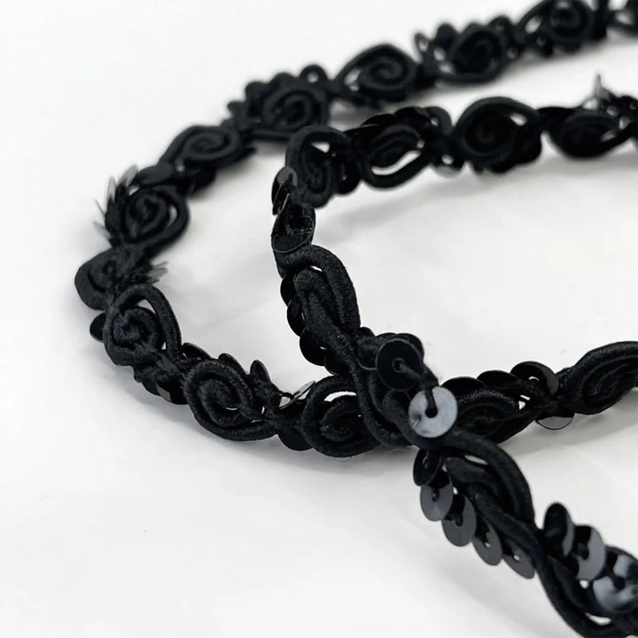 ANI Accessories close-up of thin sequence lace showing black sequins on the scroll cord with white color background 