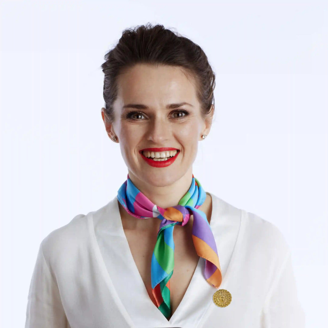 Model showcasing a lion head gold brooch on a white blouse with a colorful scarf