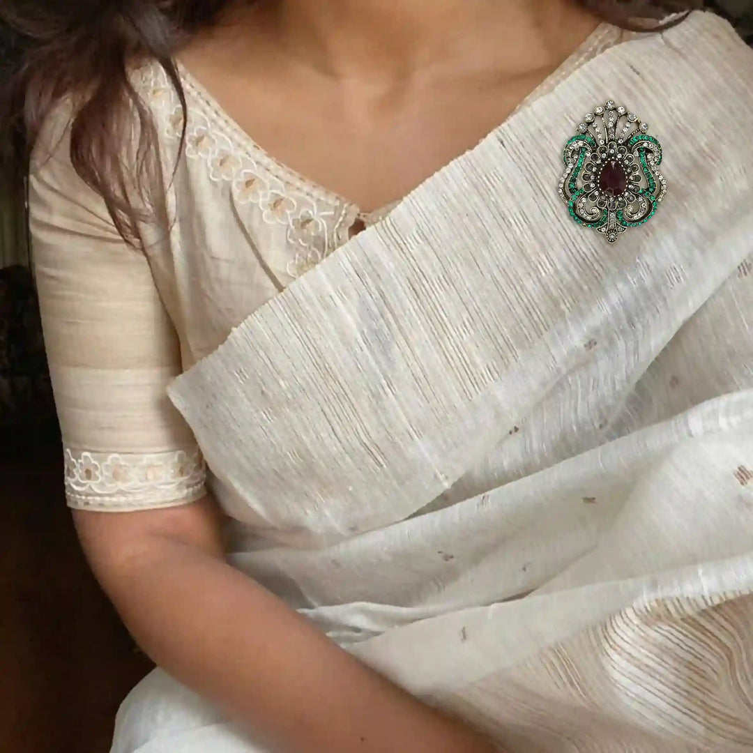 ANI Accessories Victorian rhinestone brooch pinned on the pallu of an ivory saree 