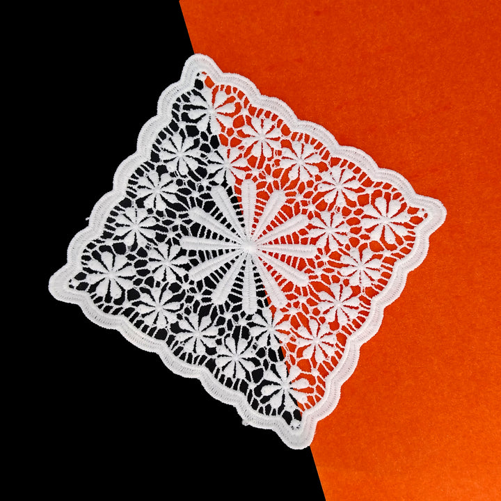 ANI Accessories white flower patch for clothes tilted on a black and orange background 