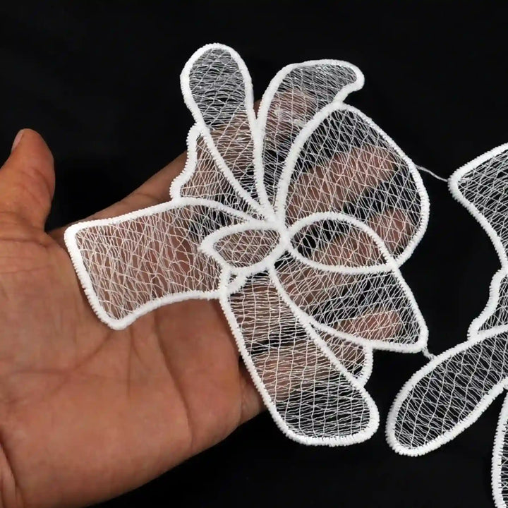 ANI Accessories white spun poly flower patch held in hand to show its size and see-through petals 