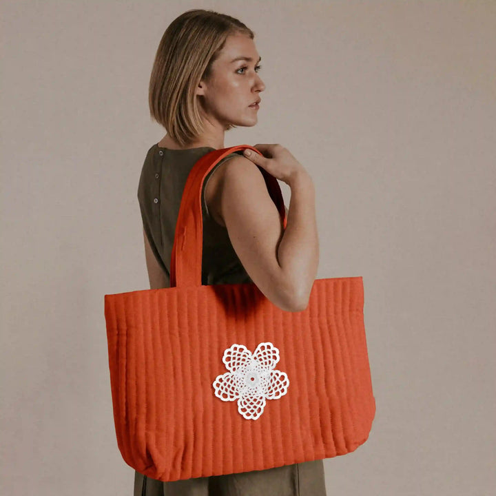 ANI Accessories white flower patch for bags stitched on an orange tote bag 