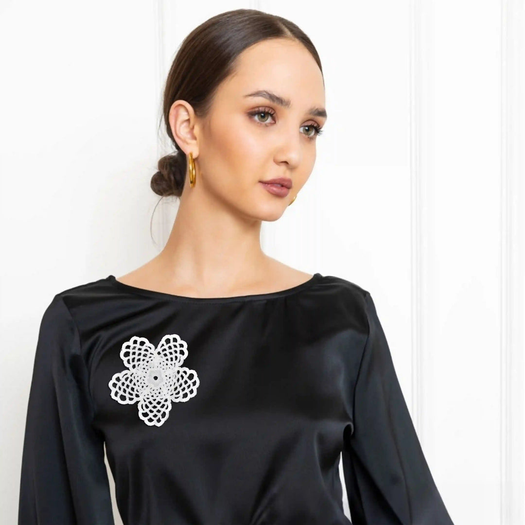 ANI Accessories white lace flower patch on the front of a black top worn by a model with white color background 
