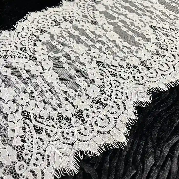 ANI Accessories close-up of the eyelash edge on wide Chantilly lace trim with black valvet cloth background 