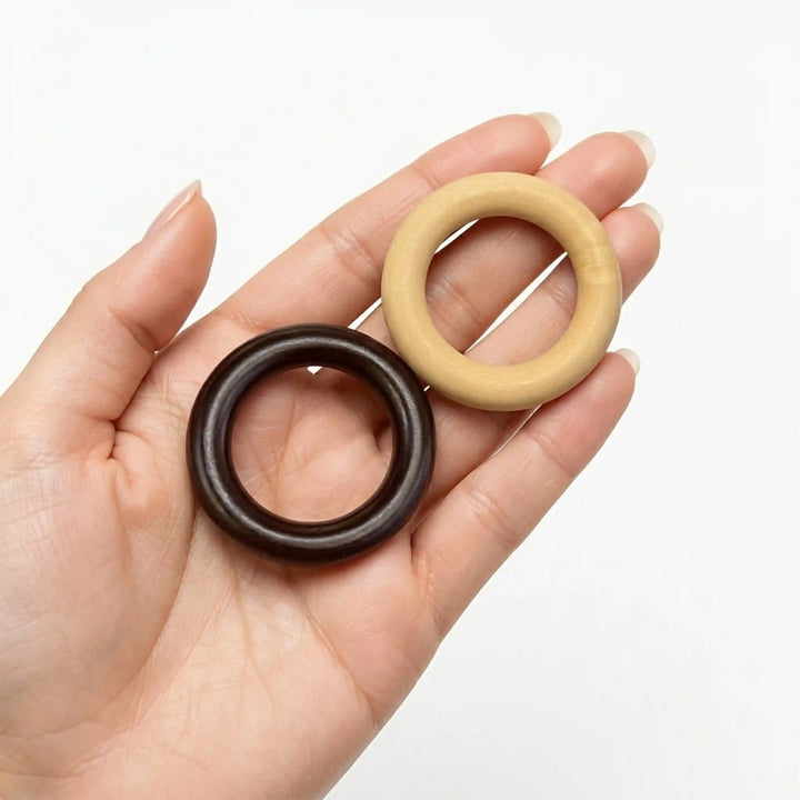 ANI Accessories walnut brown and natural wooden O-ring buckles resting in an open palm to show real size in white color background 